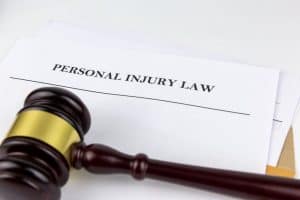 A wooden gavel rests on papers titled 'Personal Injury Law.'
